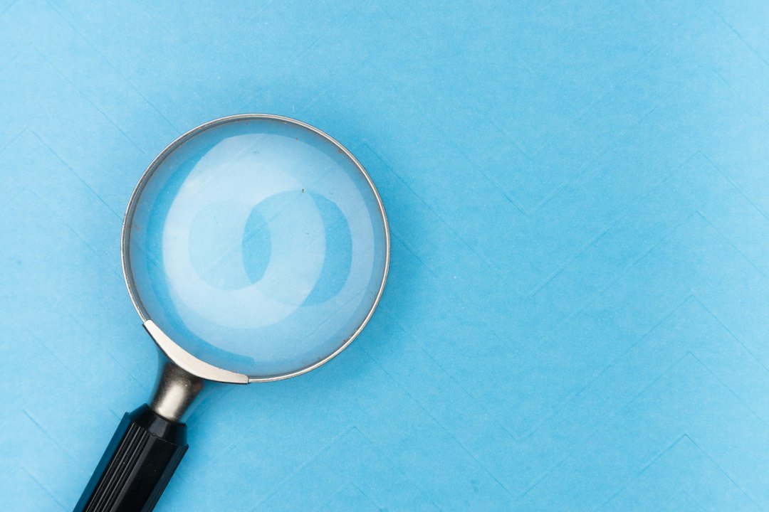 Magnifying glass on documents, representing verifying a company's claims and registration