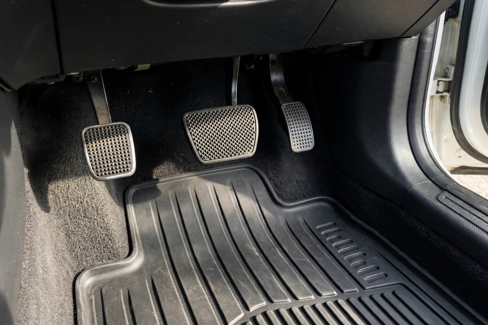 Diagram of manual car foot pedals showing the clutch, brake, and gas pedal from left to right